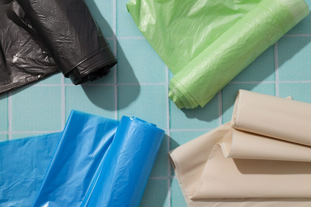 Rolls of garbage bags on blue background, top view